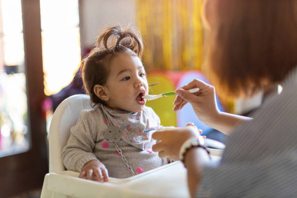 istock Mother feeding her baby with spoon 1189121970