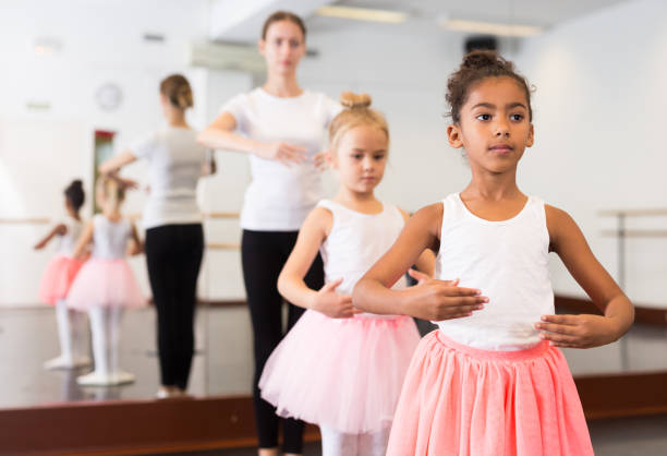 istock Dance teacher helping her little girls students 1189122600