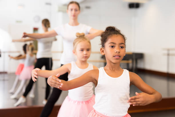 istock Dance teacher helping her little girls students 1189122640