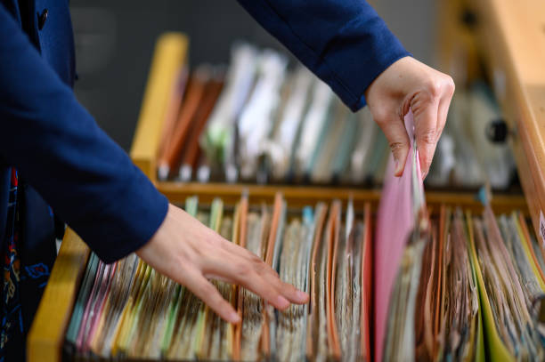 istock Female staff searching for documents in filing cabinets at the office 1189123453