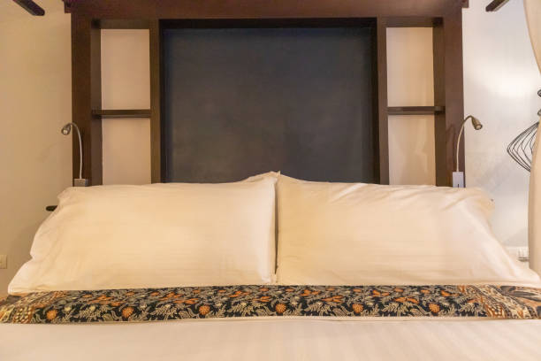 istock sweet romantic white bed sheets and pillow at hotel 1189124809