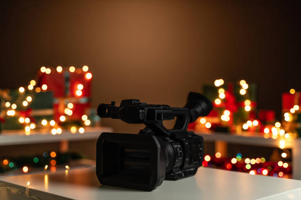 istock Home video camera in front Christmas lights  and presents in background 1189125645