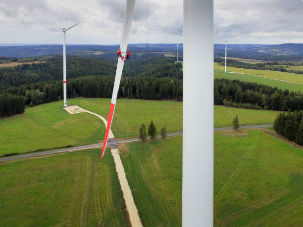 istock Tow high rise rope access technician doing blade repair on wind turbine high up 1189126692