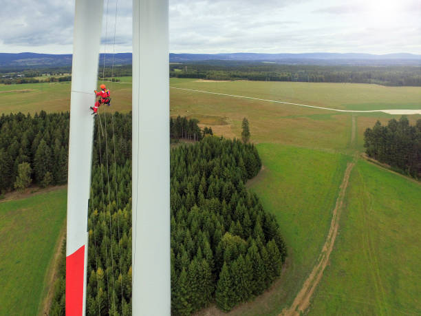istock View from drone on high rise rope access technician doing inspection of blade on wind turbine 1189126694