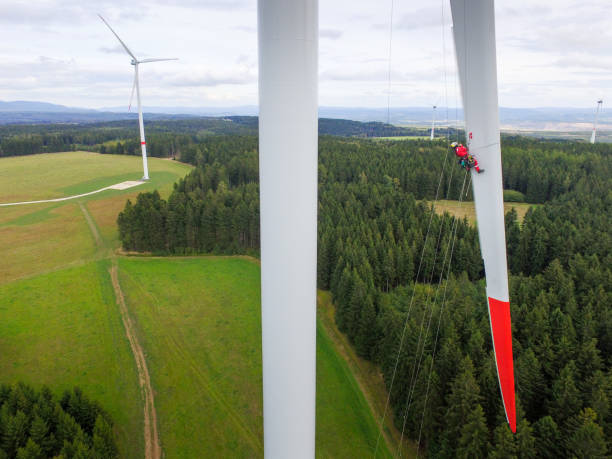 istock Iconic view on High rise rope access technician doing inspection of blade on wind turbine 1189126696