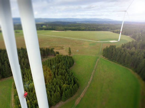 istock View from drone on high rise rope access technician doing inspection of blade on wind turbine 1189126709