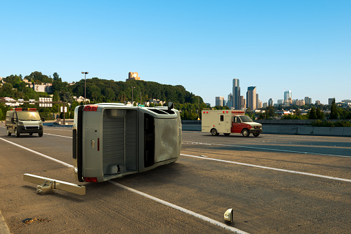 3D rendering of a car accident with a van tipped over and emergency vehicles approaching.