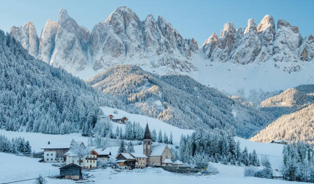 The small village in Dolomites mountains in winter. The small village Val di Funes covered in snow, with Dolomites mountains, South Tyrol, Italy. snowy river stock pictures, royalty-free photos & images