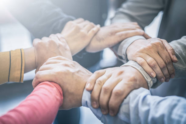 A group of young people hold strong hands.