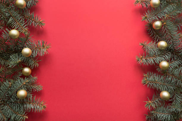 istock Christmas frame with fir branches, golden balls on red background. Space for text, view from above, flat lay. Happy New Year. 1189129742