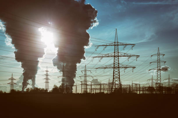 silhouettes of electricity pylons and two power plants with pollution - toxic substance fumes environment carbon dioxide imagens e fotografias de stock