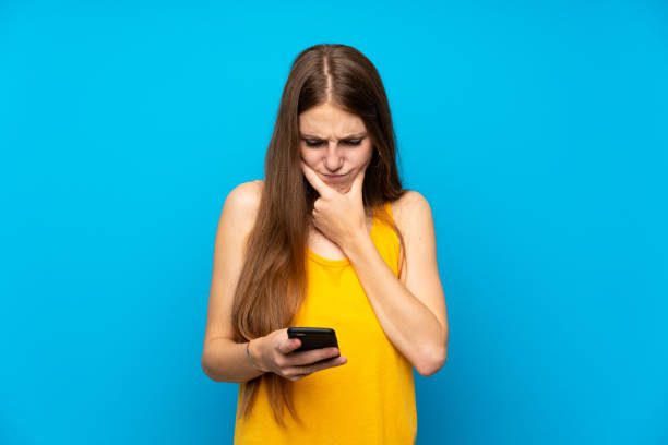 istock Young woman with long hair over isolated blue wall thinking and sending a message 1189129918