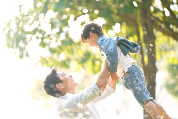 istock young asian father and son having fun outdoors in park 1189130081