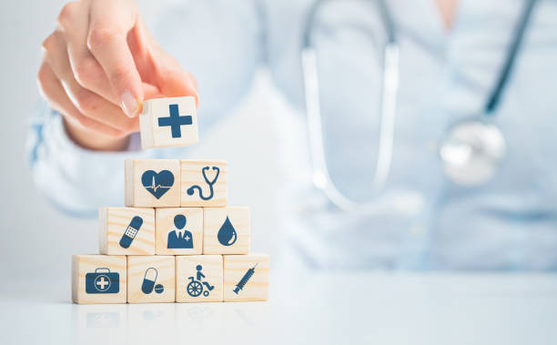 Health insurance - concept. Hand arranging wood block with healthcare medical icon. Health insurance - concept. healthcare and medicine concept stock pictures, royalty-free photos & images