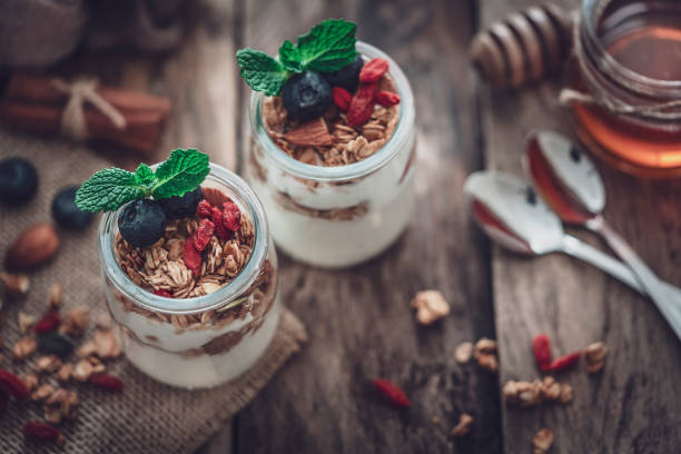 istock Healthy food: yogurt and granola on wooden table. Retro styled 1189133192