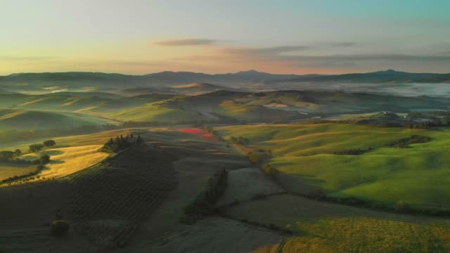 Aerial flyover the beautiful sunset landscape in Tuscany, Italy.