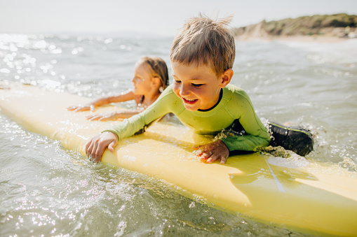 Photo of brother and sister surfing together