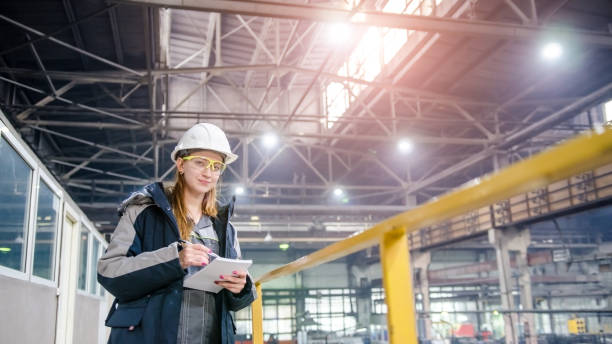 istock Young female technician in uniform, protective eyeglasses and helmet 1189136000