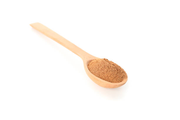 istock Wooden spoon with cinnamon powder isolated on white background 1189138338