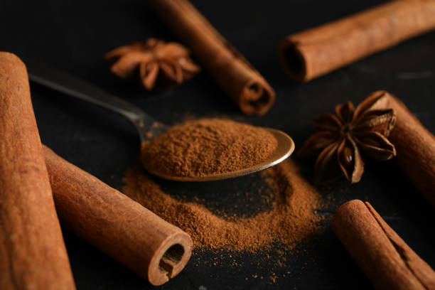istock Cinnamon sticks, anise and spoon on black background, space for text 1189138491