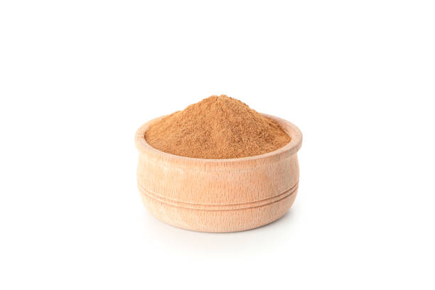 istock Wooden bowl with cinnamon powder isolated on white background 1189139446