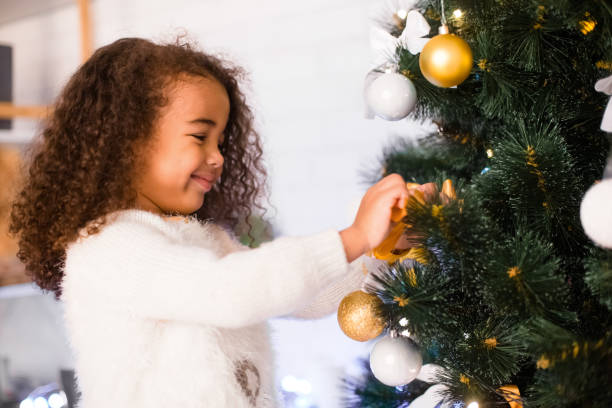 istock Cute african american girl decorating Christmas tree 1189140270