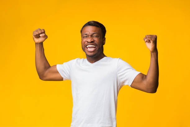 istock Emotional Afro Guy Shouting Shaking Fists Standing On Yellow Background 1189142884