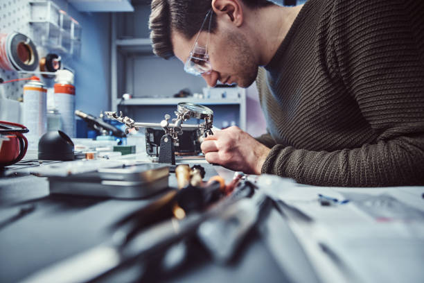 technicien électronique travaillant dans l'atelier de réparation - male magnifying glass caucasian technician photos et images de collection