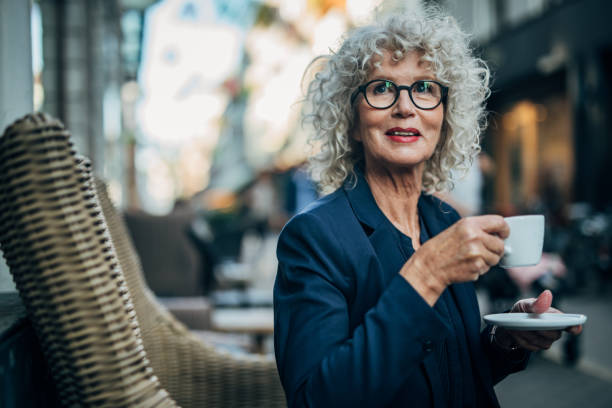 istock Mature woman drinking coffee in sidewalk cafe 1189143584