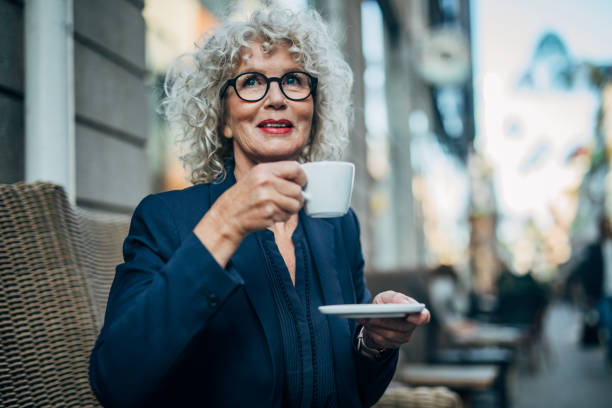 istock Mature woman drinking coffee in cafe 1189143641