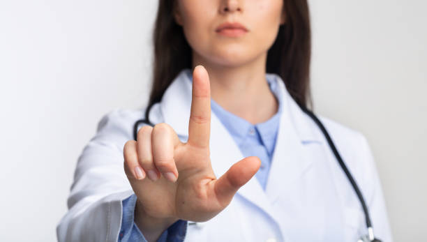 istock Doctor Lady Touching Invisible Medical Touchscreen Standing, Studio Shot, Cropped 1189145154