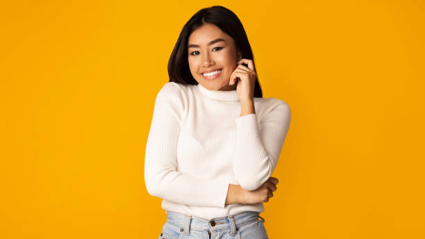 istock Confident asian girl posing over yellow background 1189145421