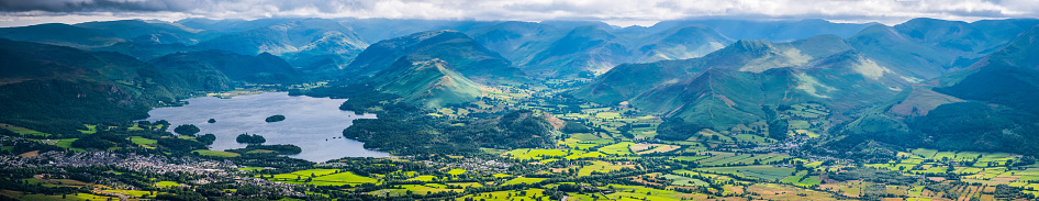 Aerial panoramic vista across the picturesque landscape of the Lake District National Park, Cumbria, UK, from the tranquil shores of Derwent Water, across the green pastures of Braithwaite to the dramatic ridges and peaks of the Western Fells.