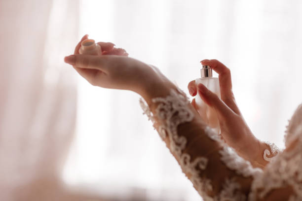 istock Wedding day. Young bride is getting ready at home in the morning. Bride applying perfume on her neck. Bride preparation. 1189148694