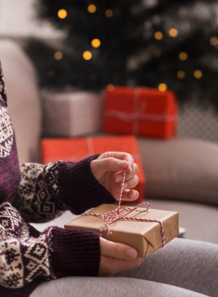 istock Woman unpacking New Year present at home over decorating tree 1189148915