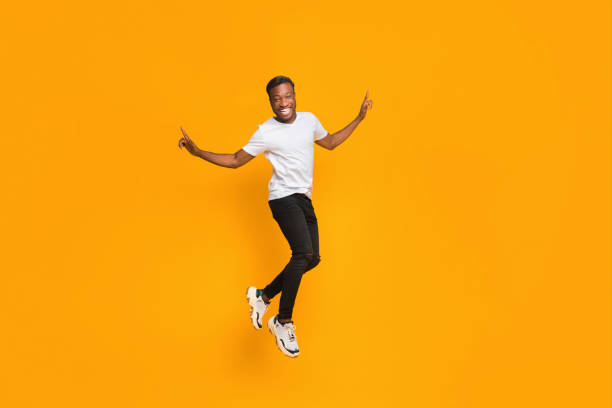 istock Joyful Afro Guy Jumping In Air Having Fun, Studio Shot 1189149068