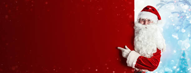 santa claus showing something on a red wall - something imagens e fotografias de stock