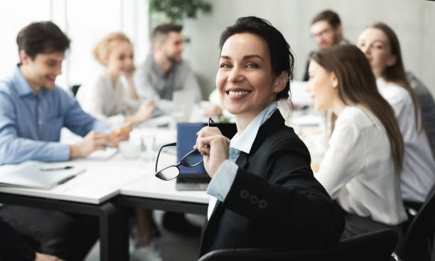 istock Female top manager smiling to camera at meeting 1189157169