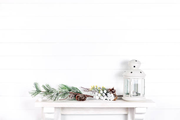 istock white wall in a room with a mantelpiece, spruce branches, cones and a lantern 1189157469