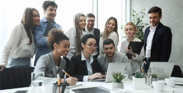 istock Happy business team analyzing data on laptop together 1189157505