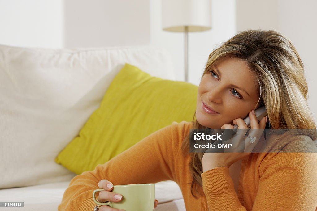 Jovem atraente mulher falando no telefone em casa - Foto de stock de Aconchegante royalty-free