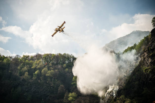 avion de pompier émettant un feu sur la forêt de montagne - airplane stunt yellow flying photos et images de collection