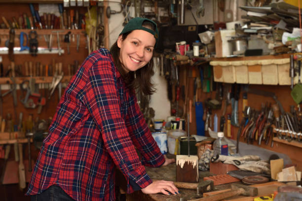istock Smiling woman posing in the small workshop with a lot off different tools 1189161861