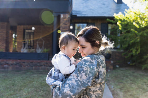 istock Female soldier enjoys holding daughter before deployment 1189163196