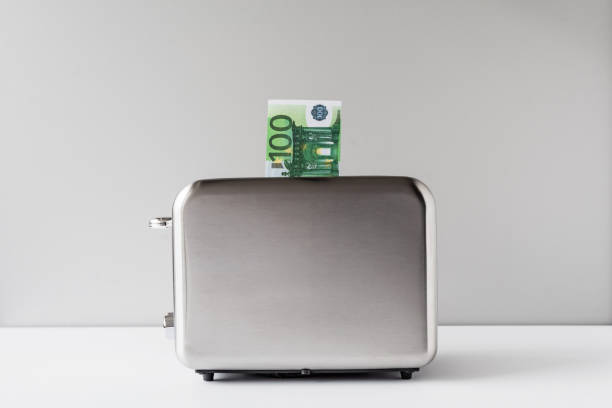 istock One hundred euro bills burning in the toaster. concept 1189165194