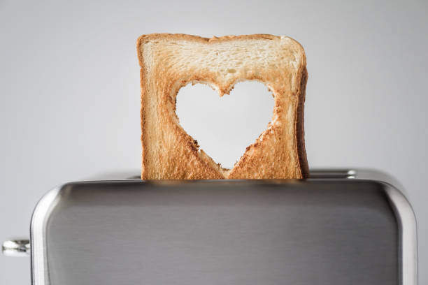 Heart shaped on roasted toasted bread in a toaster. Breakfast preparation on Valentine's Day. symbol sign of love. Concept