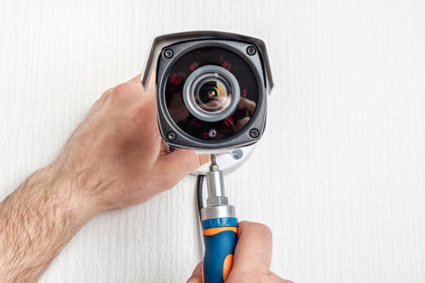 istock Close-up hands of technician adjusting CCTV camera on wall 1189170064