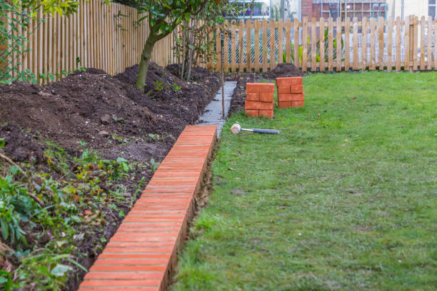 istock A string line keeping installation of a brick edging to a lawn straight. The cement footings can be seen where new bricks are stacked waiting for laying. 1189171009