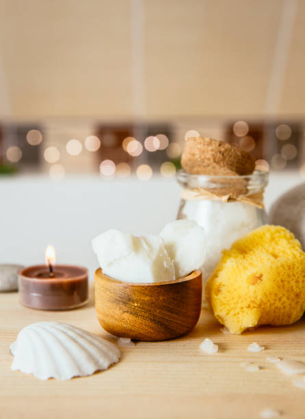 istock Replacing cosmetic products with natural coconut oil moisturizer cream. Solid coconut oil chunks in small wooden cup with other bath body care products in beige brown tile bathroom. Cozy set bokeh. 1189171241