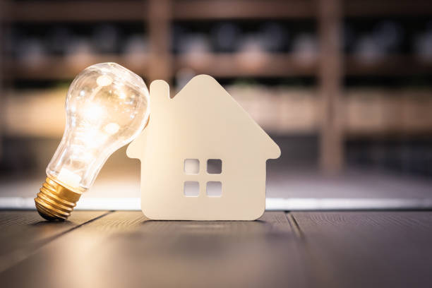 istock Light bulb with wood house on the table, a symbol for construction, Creative light bulb idea, power energy or business idea concept ecology, loan, mortgage, property or home. 1189173663